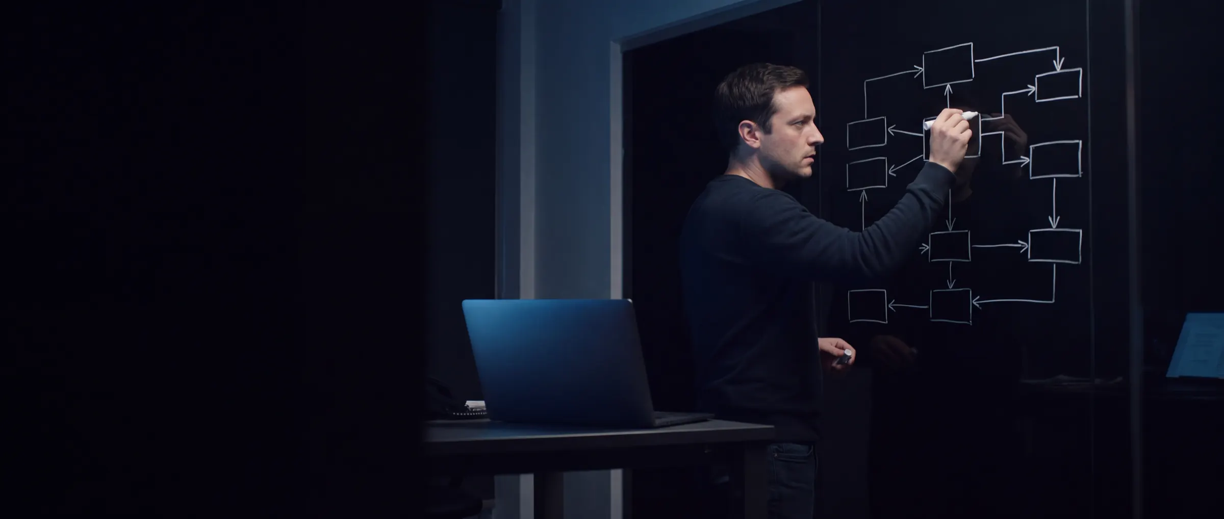 Een tester tekent op een glazen wand uit hoe alle systemen en koppelingen met elkaar verbonden zijn